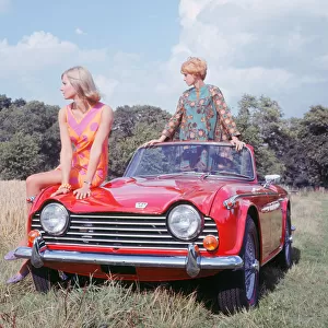 1968 Triumph TR5 with female models, (B. M. I. H. T. ). Creator: Unknown