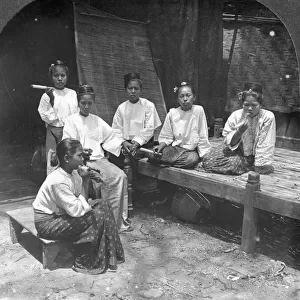 Burmese women smoking outside their home, Mandalay, Burma, 1908. Artist: Stereo Travel Co