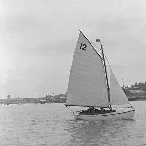 A Hamble River Class dinghy (No 12) sailing close-hauled, 1921. Creator: Kirk & Sons of Cowes