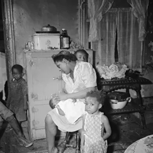 A mother getting the children ready for a neighborhood birthday party, Washington, D. C. 1942. Creator: Gordon Parks