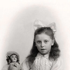 A young girl holding a doll, 20th century