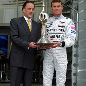 Formula One World Championship: Colin Hilton Chief Executive of the Motor Sports Association presents David Coulthard McLaren with the Hawthorn Trophy