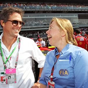 Formula One World Championship: Hugh Grant Actor on the grid with Alexandra Schieren, FIA Press Delegate on the grid