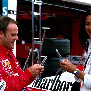 Formula One World Championship: Third placed Rubens Barrichello Ferrari, plays on his mobile phone with Megan Gale, the face of Vodafone