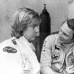 Formula One World Championship: sixth placed Ronnie Peterson Lotus talks with Niki Lauda Ferrari, who retired from the race on lap 4 with a