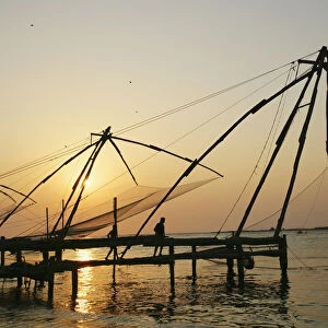 Chinese Fishing Nets Hanging In The Water At Sunset, Fort Kochi