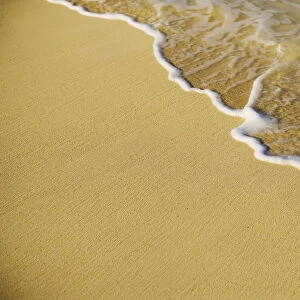 Close-Up Of Gentle Waves Washing Onto Sandy Tropical Beach