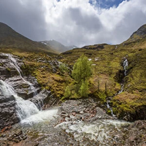 Waterfall in the Scottish Highlands with cloudy sky in Scotland, United Kingdom