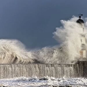 Waves Crashing Up Against A Lighthouse; Seaham, Teesside, England