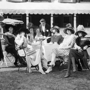 1921 Clothing Ascot Fashion Racegoers sit in a group at a table watching