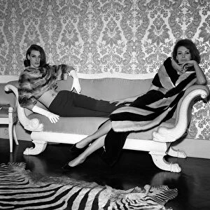 1960s Fashion Clothing December 1962 Models wearing Fur Coats reclining on a sofa