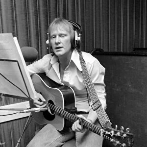 Actor Dennis Waterman, seen here in the recording studio with his guitar. December 1975
