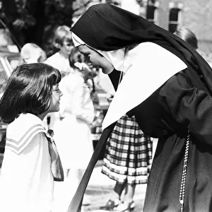 Actress Laura Carr wearing nuns habit talking to a small girl whilst holding a cigarette