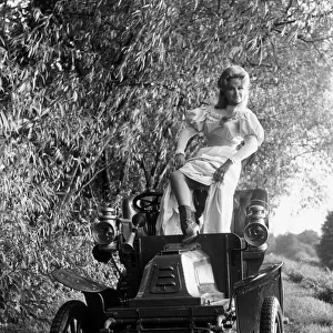Actress Martha Hyer poses on a vintage De Dion motor car which is used in her latest