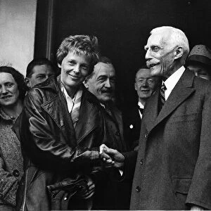 Amelia Earhart airwoman shaking hands with the American Ambassador