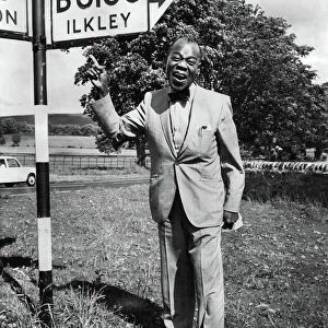 American jazz musician Louis Armstrong by a signpost in Yorskhire