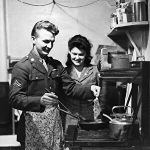 American soldier shows his English wife how he likes his steak done, circa 1944