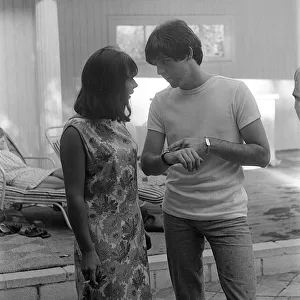 August 1964 Paul McCartney talking to girl at a pool in Private home in Bel Air Los