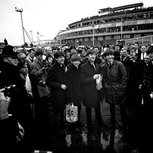 The Beatles arrive at London airport from Sweden. Surrounded by police, press and fans