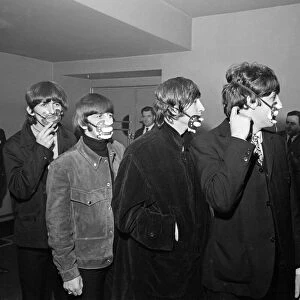 The Beatles with smog masks on before playing at the Ardwick Theare, Manchester