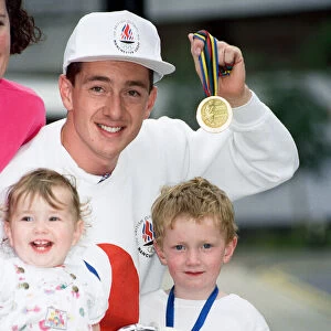British cyclist Chris Boardman poses with his family on arrival at Manchester airport as