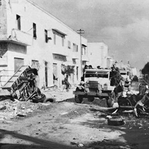 British infantry pass a wrecked transport as they enter Benghazi during Second World War
