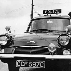 A Cambridgeshire police officer driving a Ford Anglia police car at Mildenhall