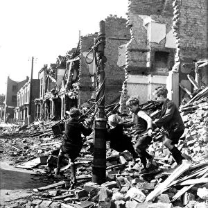 Children playing on a makeshift swing amidst rubble during the blitz attack of the German