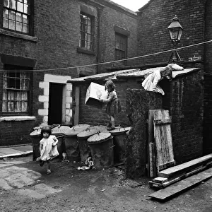Children playing outside slum housing in Dickenson Street, Oldham. 1st June 1962