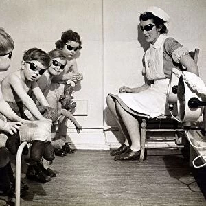 Children undergoing sunray treatment along with their dolls