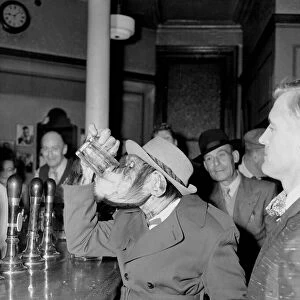 Chimp having a pint with his human friends at a pub - drinking beer May 1956