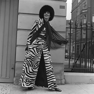 Christine Maxey wearing a zebra print trouser-suit and tunic top with black hat