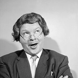 Comedian Benny Hill pictured at home wearing a wig and glasses May 1958