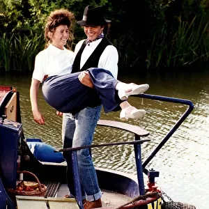 David Essex singer and actor on a barge boat carring a woman in a scene from his TV