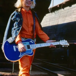 Debbie Harry January 1980 Holding guitar sun glasses orange suit blue denim jacket