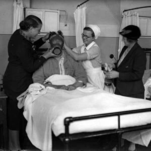 Demonstrating a gas mask on a patient in hospital in the early years of the Second World