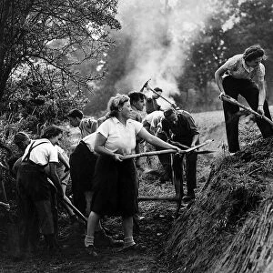 A "Ditching"party of Women of the Volunteer Land Corps at work digging a deep