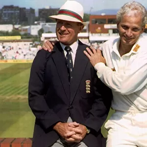 England cricketer David Gower sitting on a brick wall with commentator
