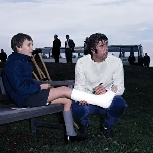 England footballer Geoff Hurst signs an autograph for a young fan in plaster caste during