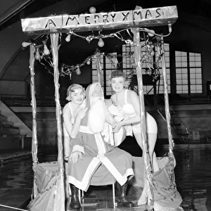 Father Christmas set adrift in a South London swimming pool with two bathing beauties