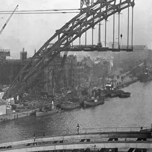 Fishing boats tied to the quay are frame by the Construction of Tyne Bridge in early 1928