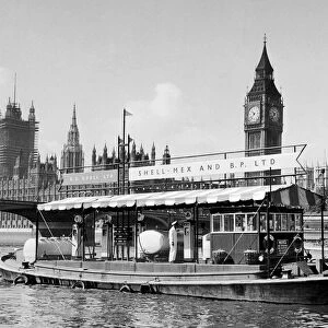 A floating Shell Mex and BP filling station on the River Thames with Big Ben