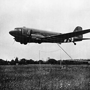 In a flower covered field in France, an American Waco CG-4 glider takes off for
