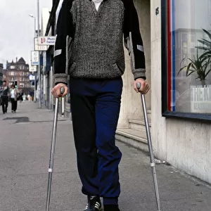 Footballer Ted McMinn in crutches after an injury on the football field September