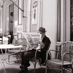 A gentleman reads the paper in a Marsaille street cafe