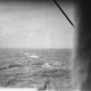 The German battleship Bismarck burns on the horizon approximately 350 miles west of
