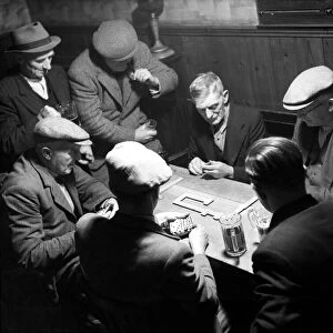 A group of elderly men taking their game of pub dominoes very seriously. Circa 1947