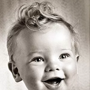 Happy baby boy with a stylish haircut. Circa 1950