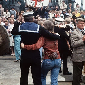 HMS Arrow Falklands War a sailor walks along arm in arm with his wife after arriving back