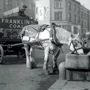 Horse and cart pulling coal through the streets of London